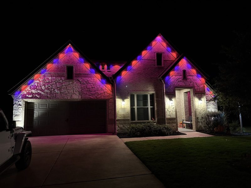 The same home lit in purple and pink for Halloween