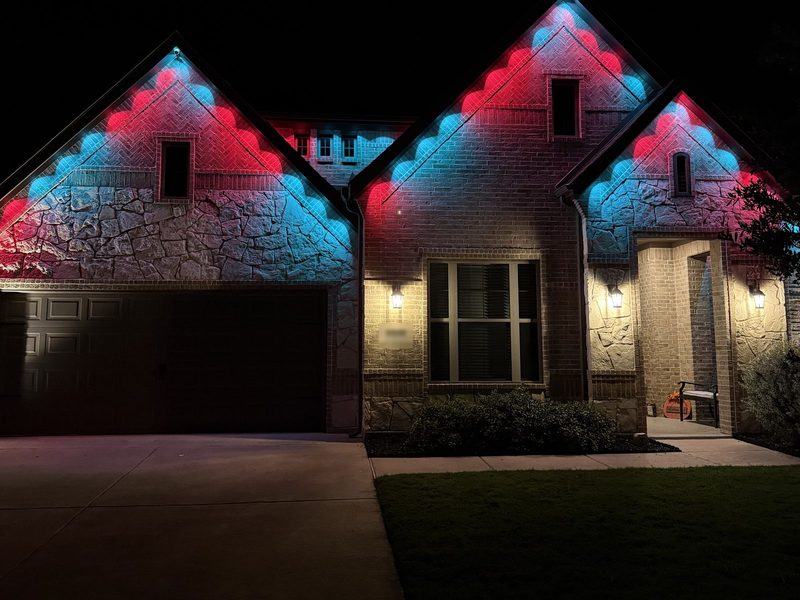 The same home lit in alternating red and blue along the rooflines